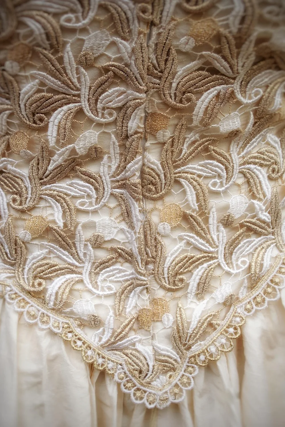 Détail de dentelle ivoire sur une robe de mariée