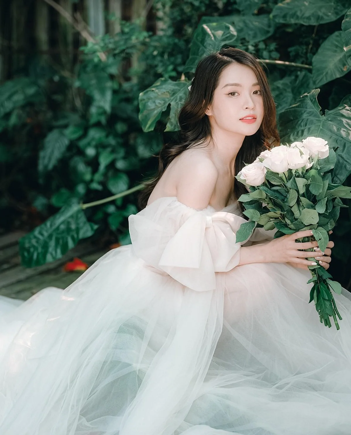 Mariée en robe de tulle épaules dénudées avec roses blanches