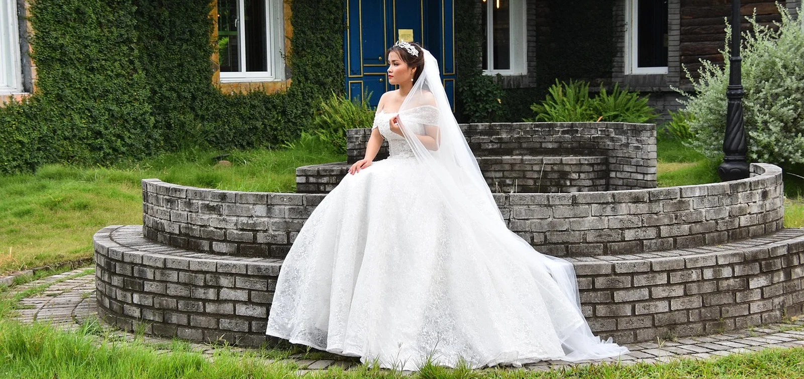 Mariée en robe blanche volumineuse devant une façade classique