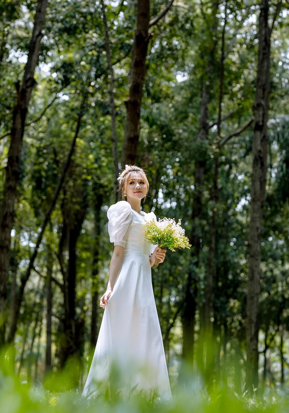 Mariée en robe blanche fluide dans un décor végétal