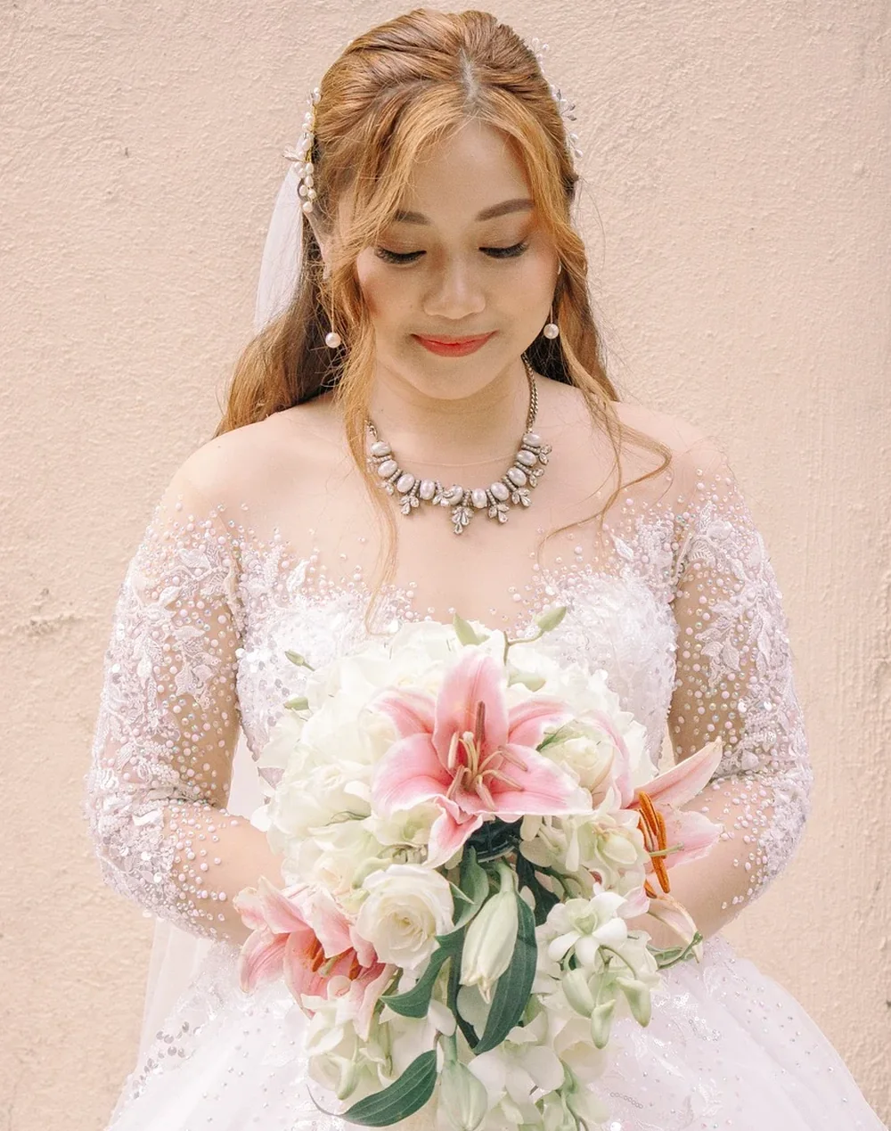 Mariée en robe de dentelle perlée avec bouquet de lys