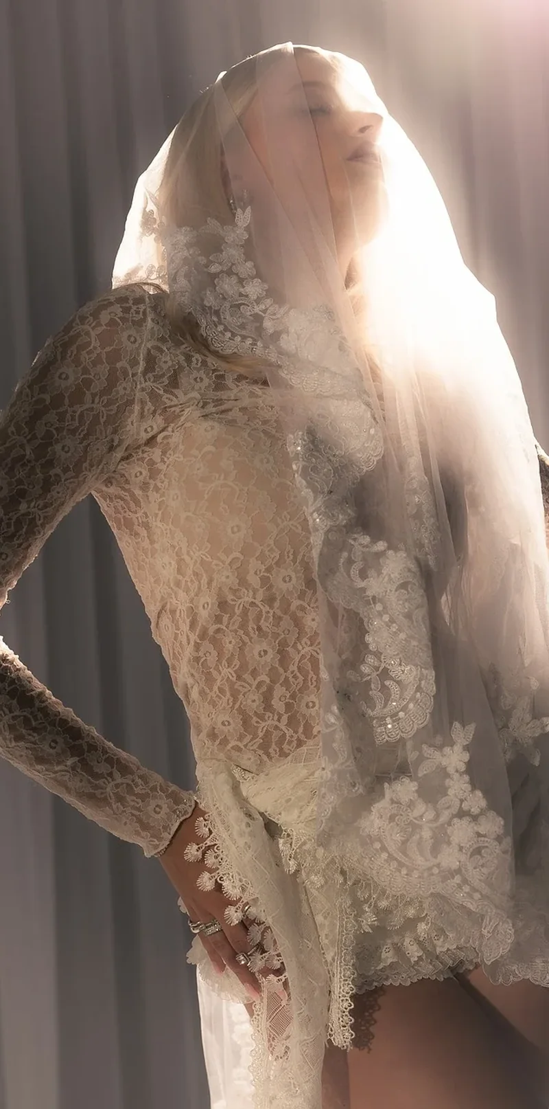 Éditorial mode avec longue dentelle, voile et lumière contrastée
