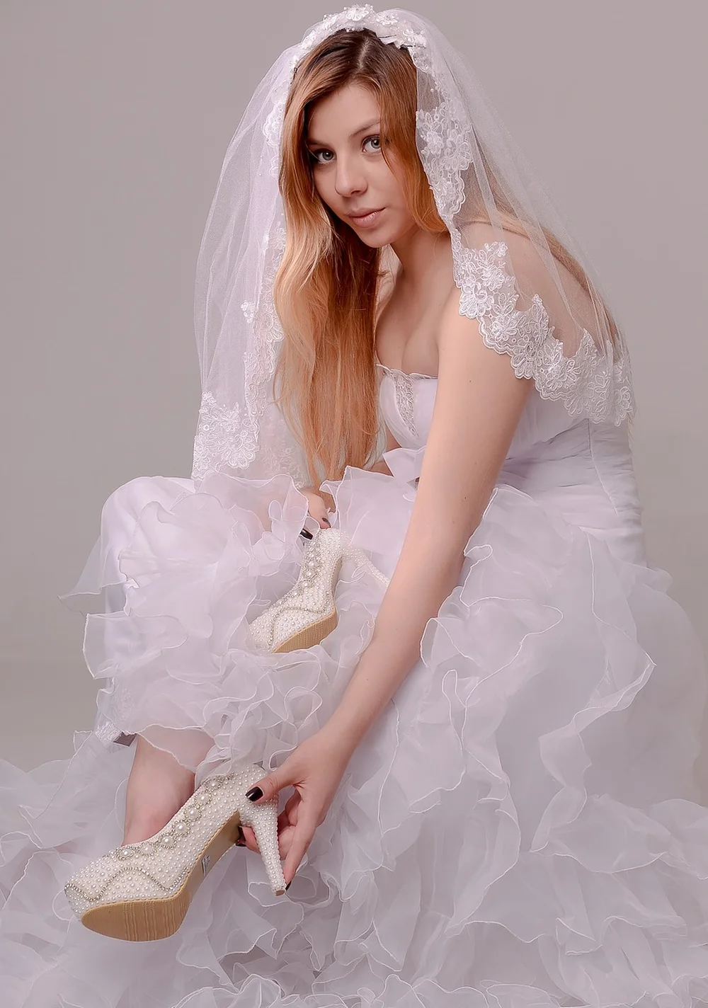 Mariée romantique en robe de tulle volumineuse avec voile en dentelle